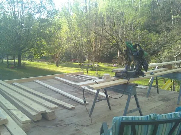 Miter saw and framing lumber on a deck under construction in Wilderville