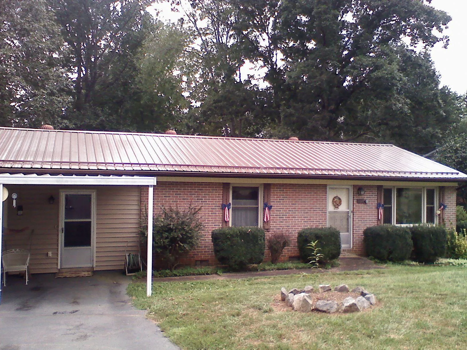 Bronze metal roof and carport on a brick ranch home — Roof Repair work by our crew in Wilderville
